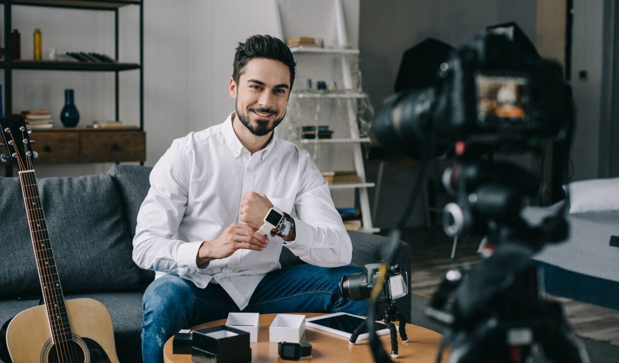 Smiling Technology Blogger Putting On New Smart Wa 54TFW25 1220x715