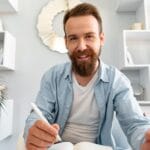 Young Bearded Man Sitting At The Desk And Taking N AP4SLGL 150x150