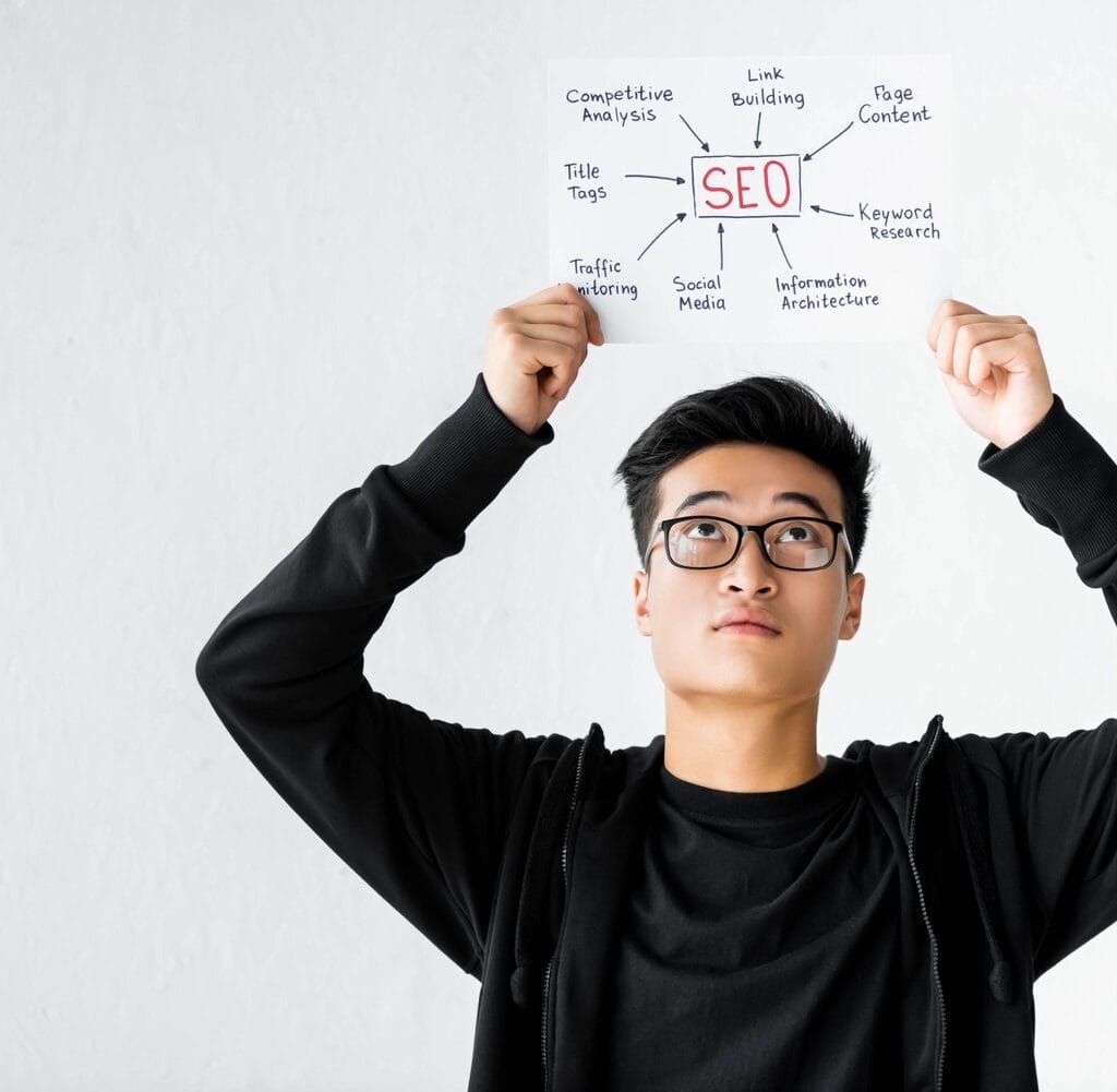 Asian Seo Manager Holding And Looking At Paper Wit SHMZ5SY 1024x1001