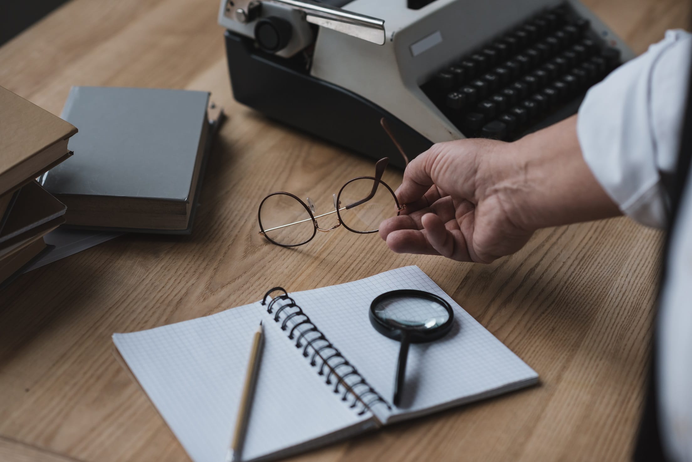 Senior Writer Putting Eyeglasses On Work Desk W7GAV6Z