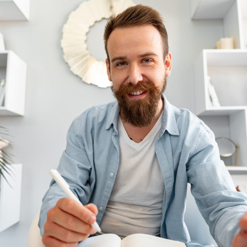 Young Bearded Man Sitting At The Desk And Taking N AP4SLGL 1024x1024