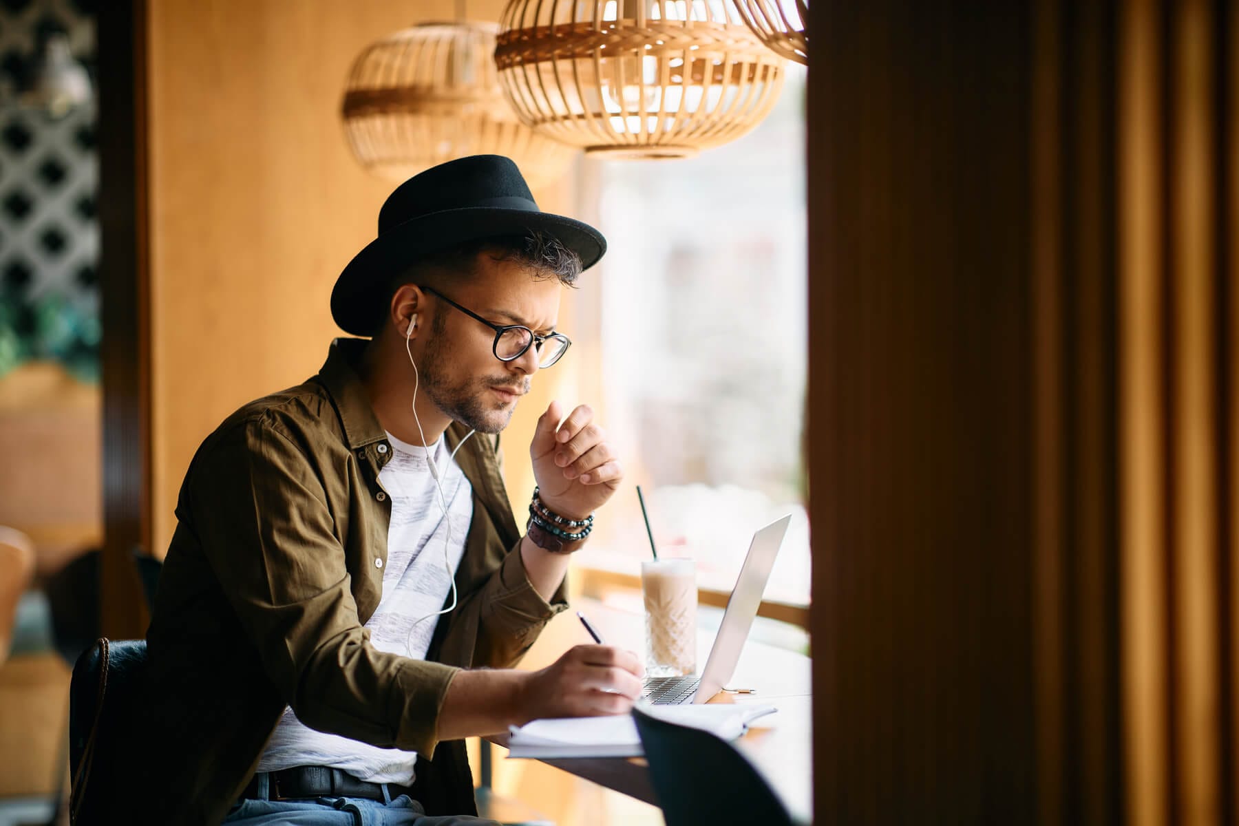 Young Man Writing In Notebook While Using Laptop A 2023 11 27 05 30 02 Utc